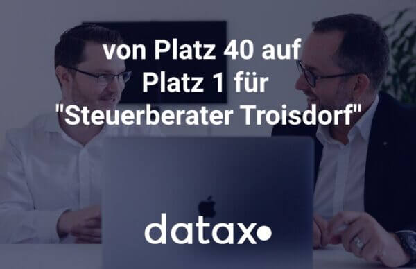 Zwei lächelnde Geschäftsleute hinter einem Laptop mit dem Text „von Platz 40 auf Platz 1 für Steuerberater Troisdorf“ und dem Datax-Logo.