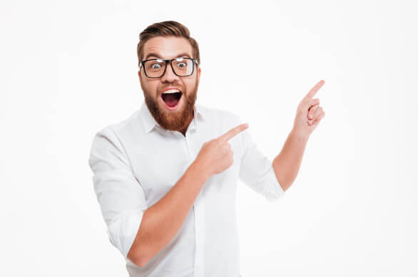 Bärtiger Mann mit Brille und weißem Hemd lächelt und zeigt nach rechts. Er verkörpert einen begeisterten Steuerberater und SEO-Experten. Weißer Hintergrund.